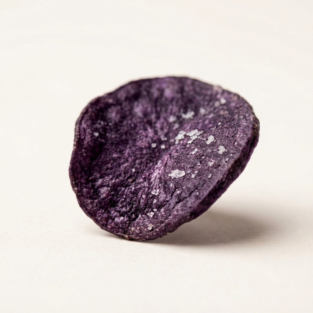 Macro of a Midnight Purple Potato chip showing deep purple striation and sea salt crystals